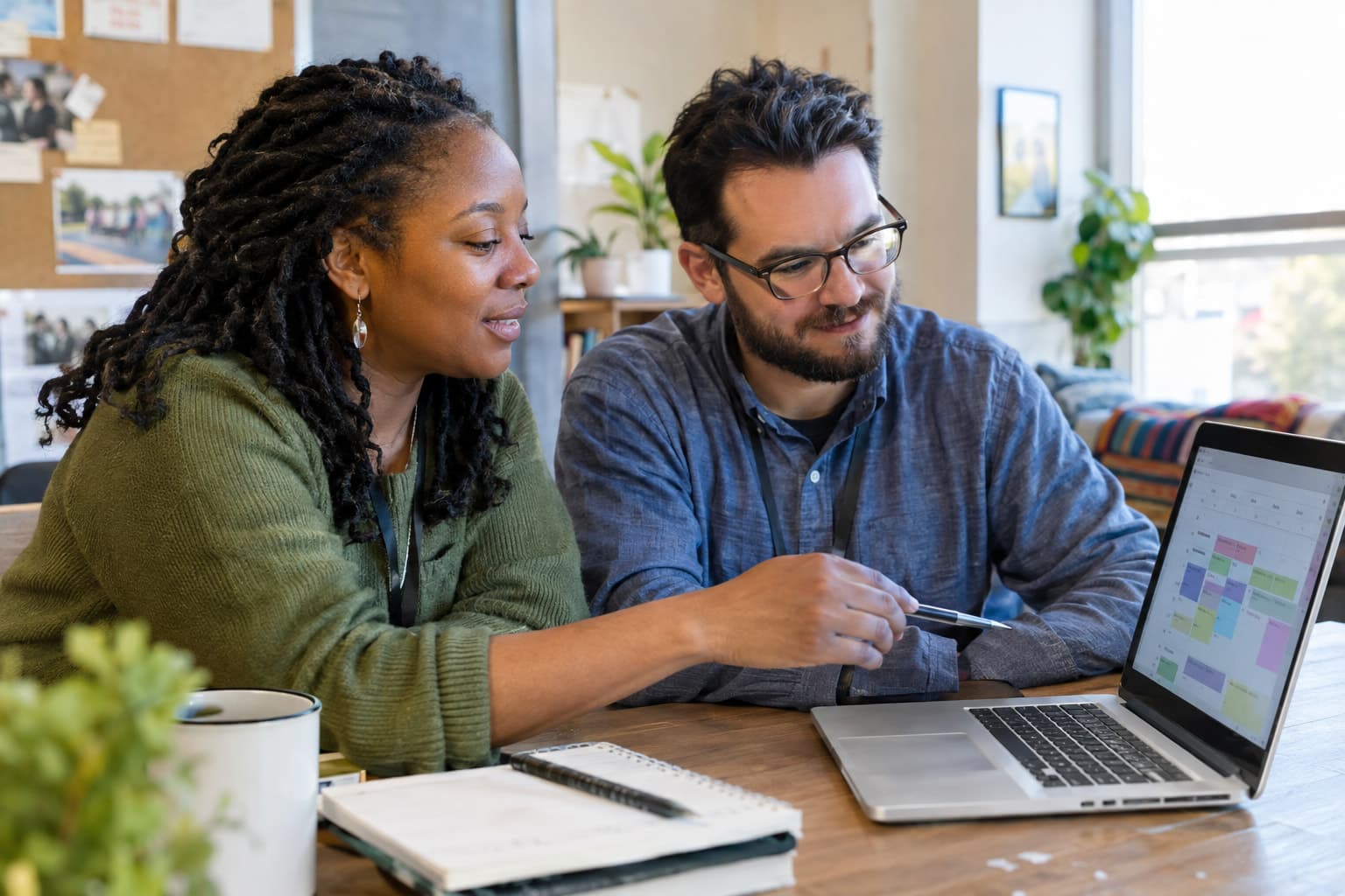 Two nonprofit staff members reviewing a shared deadline calendar on a laptop
