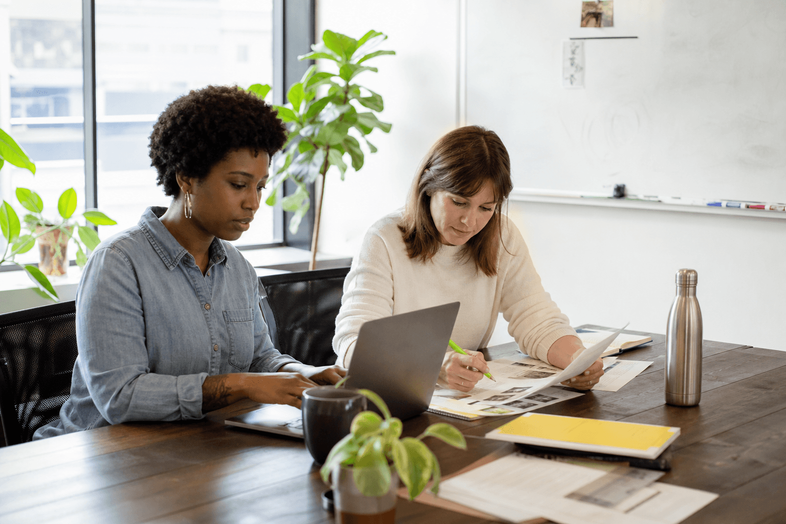 A nonprofit program director and finance lead drafting a funding request together